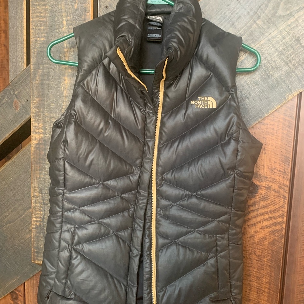 The North Face Women's Black Puffer Vest. Rare black with gold logo. Like new.